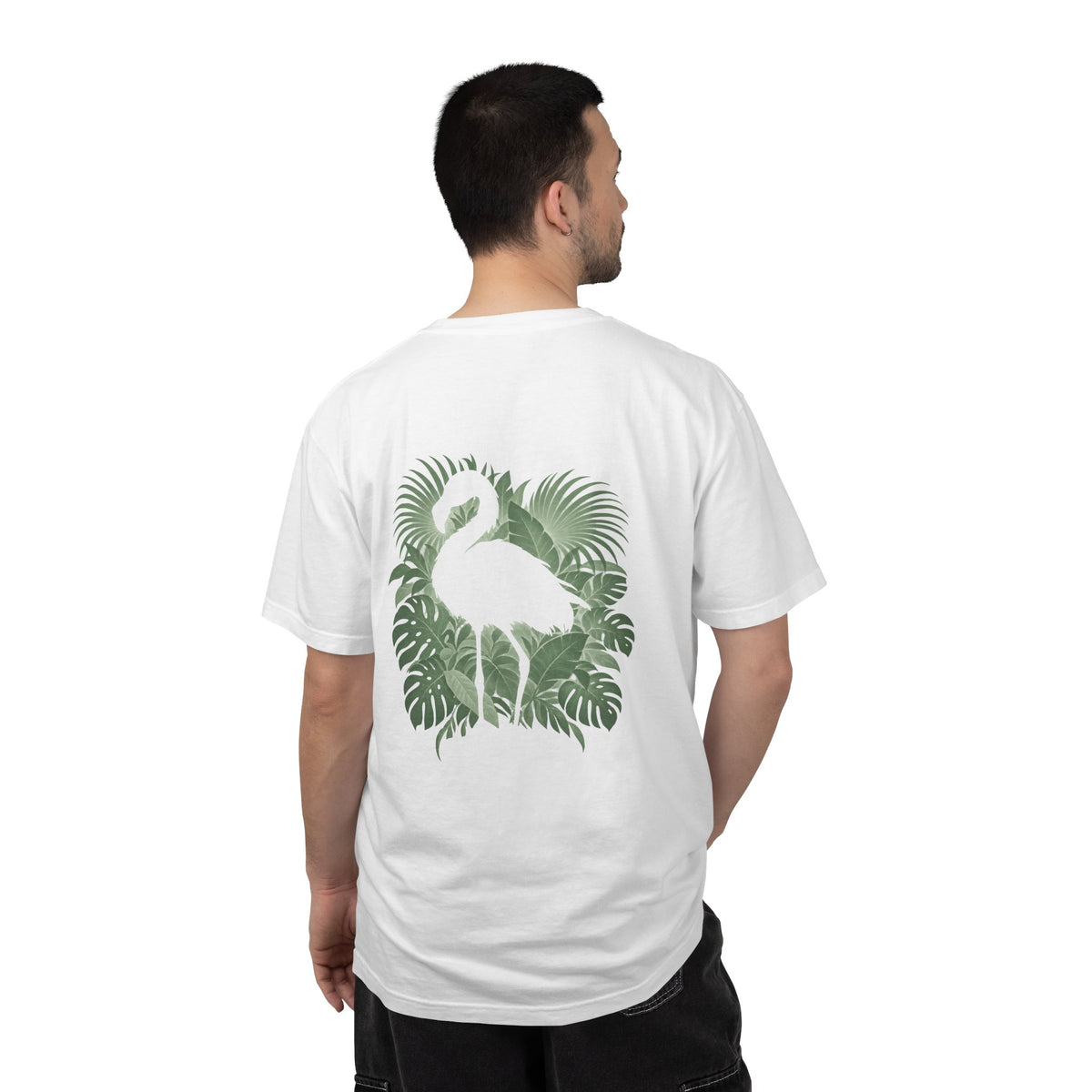 Model wearing the White Hidden Flamingo T-shirt, showing a flamingo silhouette framed by tropical leaves on the back.