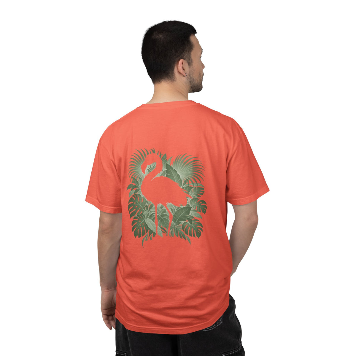 Model wearing the Bright Salmon Hidden Flamingo T-shirt, showing a flamingo silhouette framed by tropical leaves on the back.