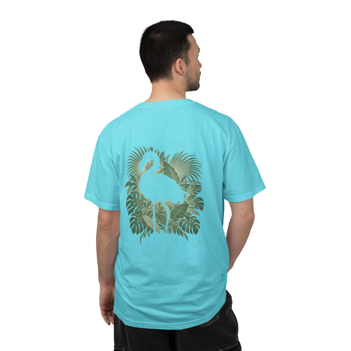 Model wearing the Lagoon Blue Hidden Flamingo T-shirt, showing a flamingo silhouette framed by tropical leaves on the back.