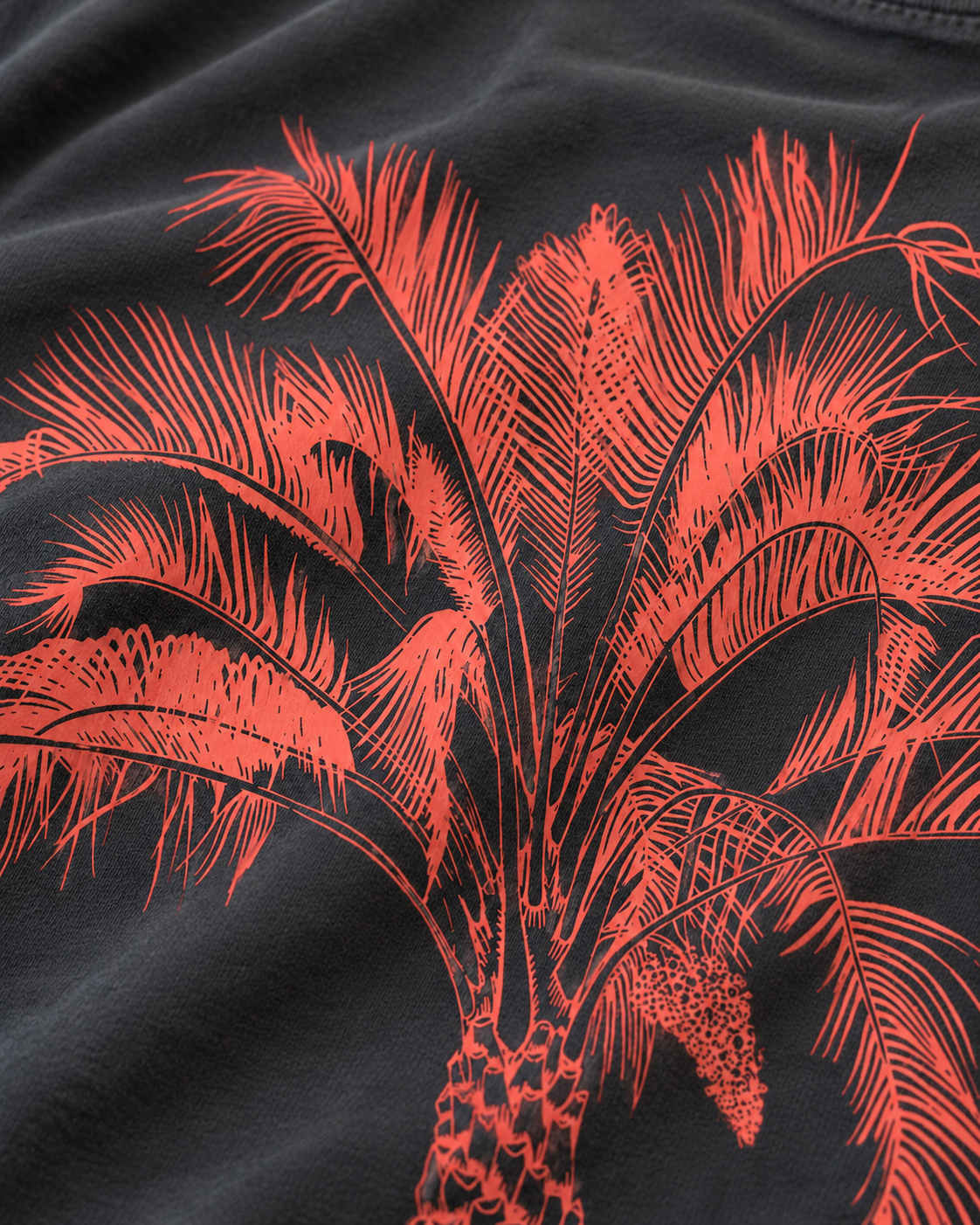 Illustrative close-up of coral Pindo palm fronds on smooth Pepper cotton jersey, cropped above all lettering.